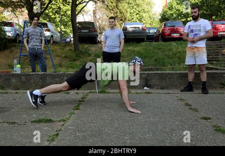 Belgrado, Serbia. 27 aprile 2020. Un gruppo di giovani si allenano nel parco durante una giornata calda e soleggiata, in mezzo alla pandemia del coronavirus COVID-19 in corso. I cittadini serbi stanno lentamente tornando alla vita normale, poiché le autorità stanno allentando alcune delle misure adottate per limitare la diffusione del coronavirus SARS-cov-2 che causa la malattia di COVID-19. Credit: Koca Sulejmanovic/Alamy Live News Foto Stock