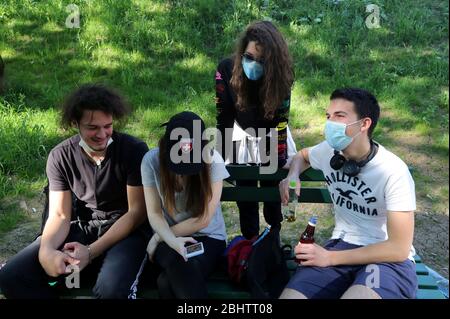 Belgrado, Serbia. 27 aprile 2020. Un gruppo di giovani che indossano maschere protettive per il viso godono di una giornata calda e soleggiata al parco, tra il coronavirus in corso COVID-19 pandemic. I cittadini serbi stanno lentamente tornando alla vita normale, poiché le autorità stanno allentando alcune delle misure adottate per limitare la diffusione del coronavirus SARS-cov-2 che causa la malattia di COVID-19. Credit: Koca Sulejmanovic/Alamy Live News Foto Stock