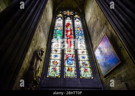 Vetrata, statua e pittura all'interno della cattedrale di Rouen a rouen Francia con luce che risplende di colori sulle pareti Foto Stock