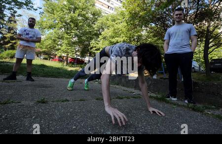 Belgrado, Serbia. 27 aprile 2020. Un gruppo di giovani si allenano nel parco durante una giornata calda e soleggiata, in mezzo alla pandemia del coronavirus COVID-19 in corso. I cittadini serbi stanno lentamente tornando alla vita normale, poiché le autorità stanno allentando alcune delle misure adottate per limitare la diffusione del coronavirus SARS-cov-2 che causa la malattia di COVID-19. Credit: Koca Sulejmanovic/Alamy Live News Foto Stock