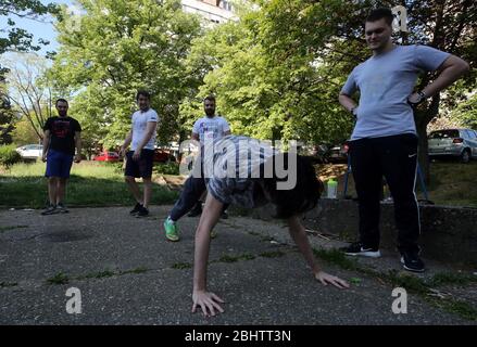 Belgrado, Serbia. 27 aprile 2020. Un gruppo di giovani si allenano nel parco durante una giornata calda e soleggiata, in mezzo alla pandemia del coronavirus COVID-19 in corso. I cittadini serbi stanno lentamente tornando alla vita normale, poiché le autorità stanno allentando alcune delle misure adottate per limitare la diffusione del coronavirus SARS-cov-2 che causa la malattia di COVID-19. Credit: Koca Sulejmanovic/Alamy Live News Foto Stock