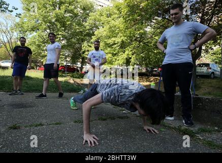 Belgrado, Serbia. 27 aprile 2020. Un gruppo di giovani si allenano nel parco durante una giornata calda e soleggiata, in mezzo alla pandemia del coronavirus COVID-19 in corso. I cittadini serbi stanno lentamente tornando alla vita normale, poiché le autorità stanno allentando alcune delle misure adottate per limitare la diffusione del coronavirus SARS-cov-2 che causa la malattia di COVID-19. Credit: Koca Sulejmanovic/Alamy Live News Foto Stock