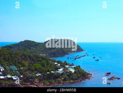 Isola tropicale verde e barche da pesca in mare. Concetto di viaggio e relax. Foto Stock