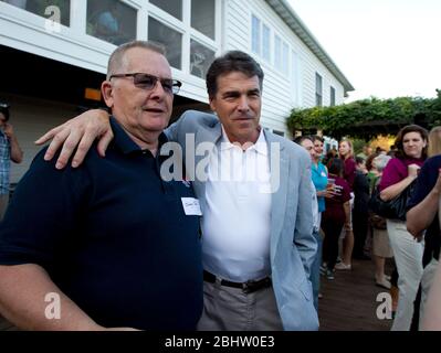 Cedar Rapids, Iowa USA, 15 agosto 2011: Rick Perry (r), il governatore presidenziale fiducioso del Texas, si pone con un sostenitore ad un ricevimento privato. Perry è entrato nella gara per la nomina repubblicana al presidente la scorsa settimana. ©Bob Daemmrich Foto Stock