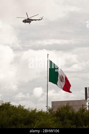 Brownsville Texas USA, 2010 settembre: Un elicottero militare della Marina messicana pattuglia il fiume Rio Grande mentre sorvola una grande bandiera messicana al confine con Brownsville, Texas, venerdì pomeriggio a seguito di segnalazioni di sparatorie multiple a Matamoros tra cartelli della droga e forze di sicurezza governative. Più di due dozzine di reporter sono stati uccisi negli incidenti. ©Bob Daemmrich Foto Stock