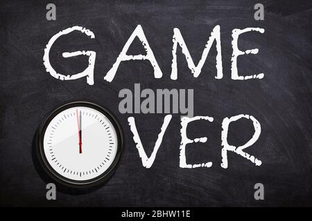 Game over testo scritto a mano con gesso bianco su lavagna o Blackboard.Time è finito concetto. Foto Stock