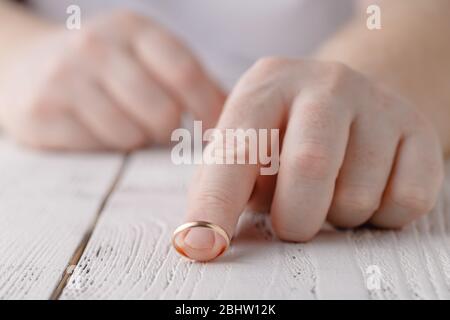 L'uomo rimuove un anello di nozze d'oro dal suo dito. Concetto di famiglia litigare, divorzio o tradimento Foto Stock