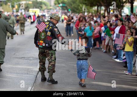 Austin Texas USA, 11 novembre 2010: Il veterano Rubio Sabino di Austin saluta il nipote Elliot Esparza nella parata annuale del Veteran's Day su Congress Avenue verso il Campidoglio dello Stato nel centro città. ©Bob Daemmrich Foto Stock