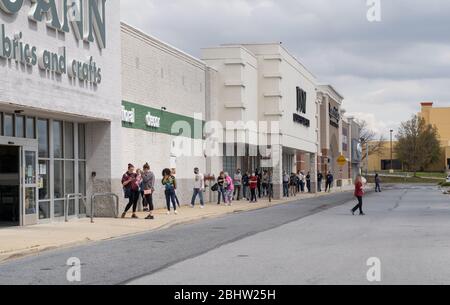 Berks County, Pennsylvania, USA, 26 aprile 2020 - persone distancia sociale mentre aspettano in una lunga linea per entrare Joann tessuto. Foto Stock