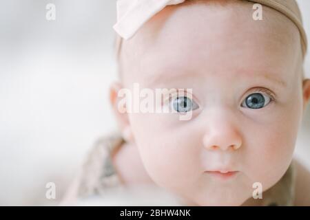 Closeup di ragazza del bambino degli occhi blu che guarda la macchina fotografica Foto Stock