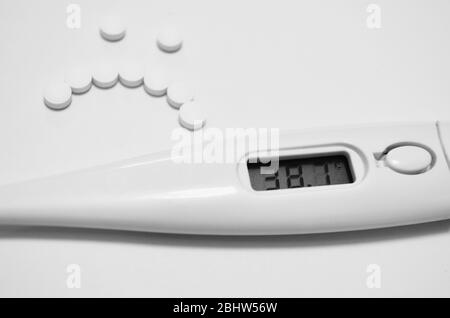 Alta temperatura in un giorno di malato, termometro e pillole a forma di sorriso triste Foto Stock