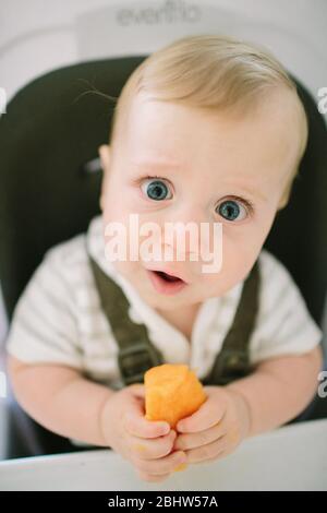Bambino che fa un'espressione divertente come prova un nuovo cibo Foto Stock