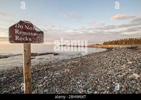 Segno sulla spiaggia di avvertimento turisti di non rimuovere le rocce ad Acadia, Maine Foto Stock