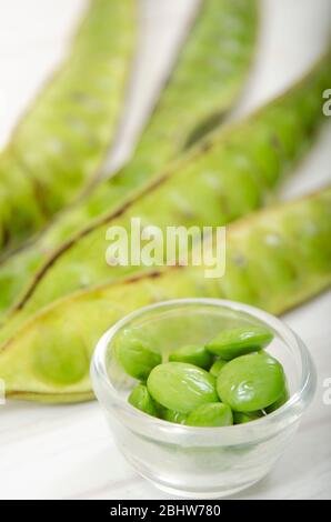 Parikia speciosa (petai, fagiolo amaro, fagiolo ritorto, fagiolo stinker o fagiolo stinch) su tavola di legno bianco Foto Stock