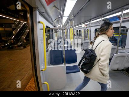 Vancouver, Canada. 27 aprile 2020. Un passeggero entra in un treno vuoto presso una stazione Skytrain di Vancouver, Canada, 27 aprile 2020. L'autorità di trasporto di Metro Vancouver TransLink ha annunciato lunedì che sta licenziando 1,492 lavoratori con un'ulteriore riduzione dei servizi a causa della massiccia recessione del ridership durante la pandemia COVID-19. A partire da lunedì pomeriggio, sono stati confermati 48,230 casi di COVID-19 in Canada e 2,701 decessi. Credit: Liang Sen/Xinhua/Alamy Live News Foto Stock