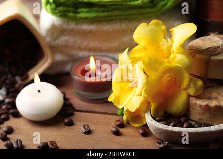 Composizione con fiore giallo e trattamento spa su sfondo tavolo in legno Foto Stock