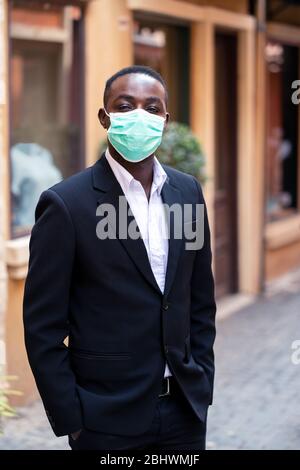 Uomo d'affari africano con maschera medica per proteggere dal virus corona o covid-19 Foto Stock