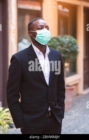 Uomo d'affari africano con maschera medica per proteggere dal virus corona o covid-19 Foto Stock