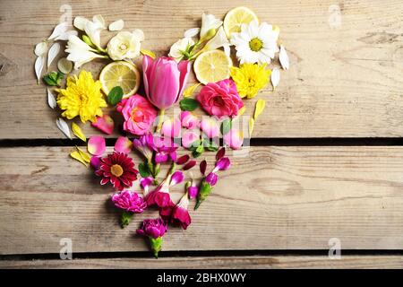 Cuore di fiori bellissimi, su tavolo di legno Foto Stock