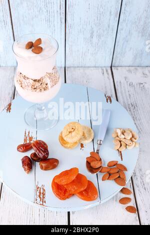 Bicchiere di crema con farinata d'avena e mandorle su sfondo di legno colorato Foto Stock