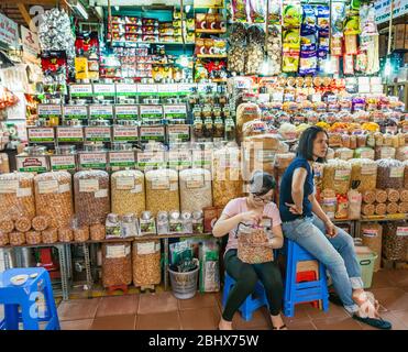 Vietnam, Saigon - Ottobre 12 2013; sfuso cibo asiatico in vendita nel mercato di ho Chi min City con due vedori in attesa di clienti. Foto Stock