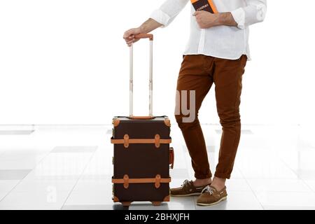 Uomo che tiene valigia in aeroporto Foto Stock