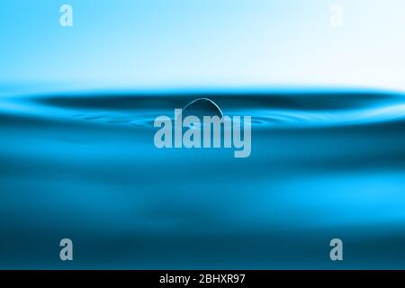 Una caduta di acqua che cade giù su una superficie di acqua Foto Stock