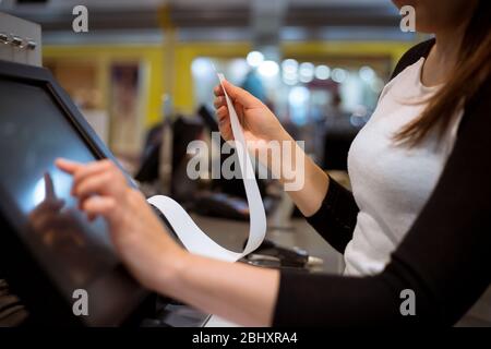 venditore, shopgirl stampa di una ricevuta, fattura per un cliente, tempo di vendita, periodo di sconto, concetto finanziario Foto Stock