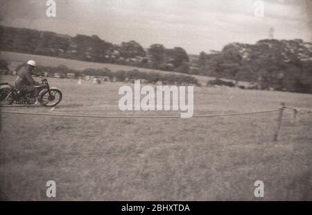 Anni '1950, storico, Motorsport, uno scrambler sulla sua motocicletta dell'epoca, che corre lungo una collina erbosa, correndo fuori dagli spettatori, Inghilterra, Regno Unito. Foto Stock