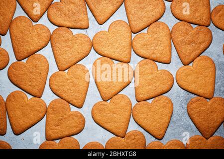 Biscotti di zenzero a forma di cuore su un tavolo di pietra. Foto Stock