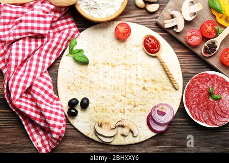 Ingredienti per cucinare la pizza su un tavolo di legno, vista dall'alto Foto Stock