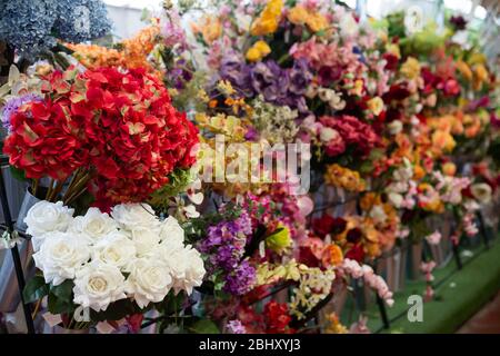 Vetrina colorata di fioreria con ampio assortimento di fiori artificiali Foto Stock