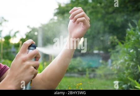 Giovane uomo spruzzare zanzara, repellente per insetti nella più avanzata, protezione degli insetti, concetto di assistenza Foto Stock