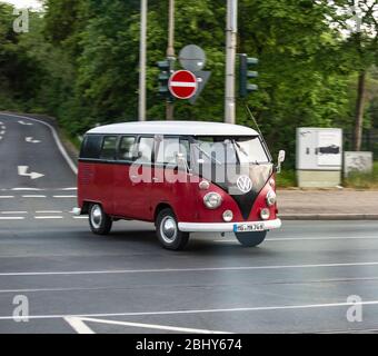 Ein ALTER VW Bus T1 aus den 60er Jahren fährt über eine Strasse a Düsseldorf. Der Bulli cappello ein H-Kennzeichen, welches für historische Fahrzeuge ausg Foto Stock