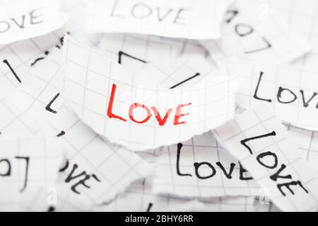 Parole AMORE scritto su carta strappata, primo piano Foto Stock