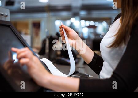 venditore, shopgirl stampa di una ricevuta, fattura per un cliente, tempo di vendita, periodo di sconto, concetto finanziario Foto Stock