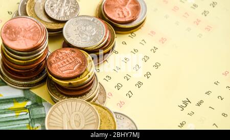 stack di monete sul calendario, closeup shot, per sfondo finanziario Foto Stock