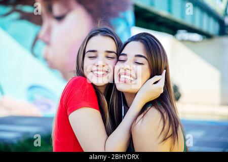 Due migliori amici femminili che si abbracciano insieme all'aperto Foto Stock