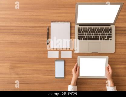 Tablet per uso umano con dispositivi elettronici sulla scrivania dell'ufficio. Schermo vuoto per il testo. VIES dall'alto. Foto Stock