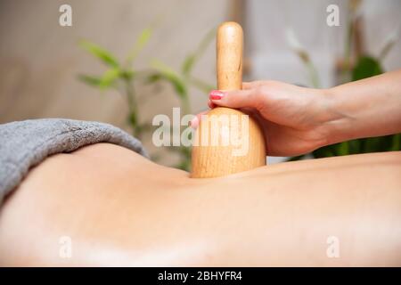 Donna che ha massaggio di maderoterapia posteriore con tazza svedese di legno Foto Stock