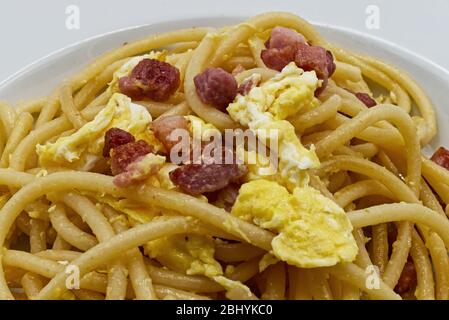 Spaghetti alla carbonara tradizionali italiani fatti in casa con tuorlo d'uovo isolato su bianco Foto Stock