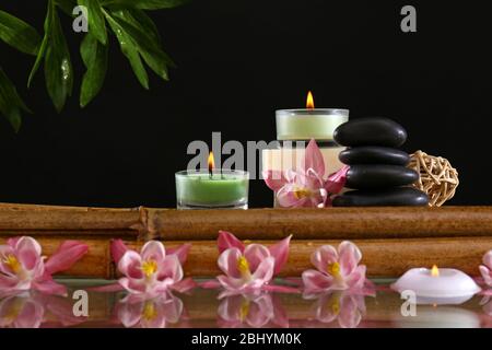 Spa ancora vita con fiori e candele su sfondo nero Foto Stock