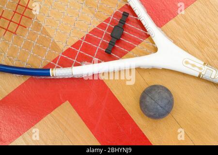Primo piano di una racchetta da squash e palla su sfondo di legno, concetto sportivo Foto Stock