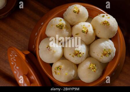 Rasgullas bianco conservato in un handi con pistacchi spruzzati. Foto Stock