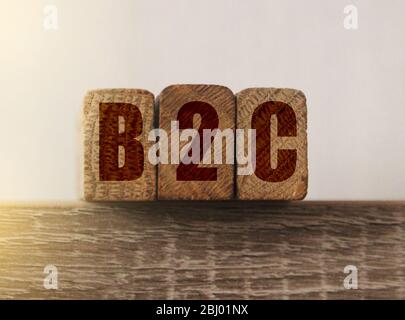 Tre cubi di legno con lettere B2C in piedi per il commercio al cliente su tavolo di legno. Concetto di marketing Foto Stock