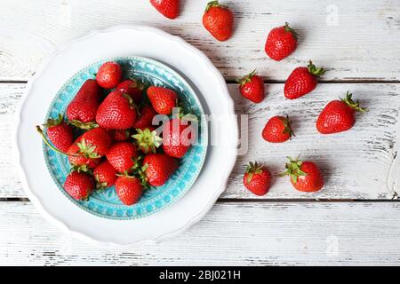 Fragole mature in piastra su tavolo di legno, vista dall'alto Foto Stock
