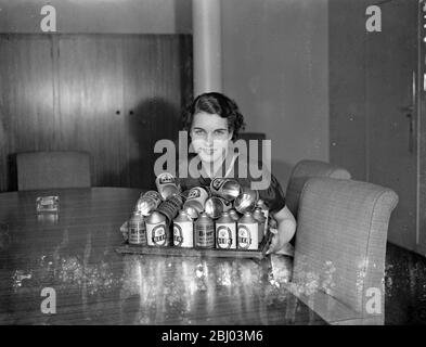 La birra in scatola prenderà meno spazio in Derby Day Hamps - Plan to Oust Bottles . - la birra in scatola è di fare la sua comparsa in derby Day Hamppers . I nuovi contenitori , che si spera saranno presto popolari in Inghilterra , si dice abbiano molti vantaggi rispetto alle bottiglie di vetro ma non influenzino in alcun modo il sapore della birra . Rispetto alla birra in bottiglia, la birra in scatola, quando viene presa in viaggio, risparmia circa il 35% nello spazio e circa il 40% in peso. La lattina viene laccata all'interno , e quindi trattata con un velo di cera che impedisce il contatto della birra con il metallo . Quattro birrifici hanno adottato finora t Foto Stock