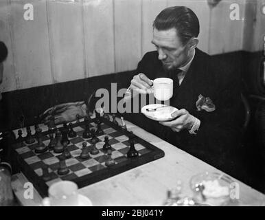 La campionessa femminile gestisce il caffè della città dedicato agli scacchi. - sedendosi teso in un silenzio rotto solo dalle tazze da caffè del Rattler, gli 'amici' degli scacchi hanno trovato un rifugio in un caffè della City of London, chiamato giustamente 'il Gambit' in Budge Row. - l'unico caffè al mondo interamente dedicato agli scacchi, è gestito dalla Miss Edith Price, che è stata a Budge Row per 37 anni e si è quattro volte campione di scacchi donna della Gran Bretagna. Molti dei giocatori provengono da tutte le parti di Londra e alcuni rimangono fino a mezzanotte. - spettacoli fotografici, caffè in mano, un giocatore pensa la sua prossima mossa a 'il Gambit'. - 7 dicembre Foto Stock