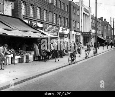 Code di pane a Bexleyheath di fronte a una sfilata di negozi. 12 novembre 1953. Foto Stock