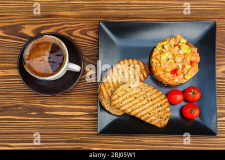 Colazione - caffè e sandwich con pesce rosso su un tavolo di legno Foto Stock